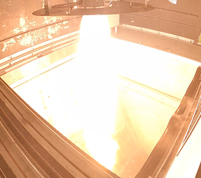 Captured frame of a powerful hybrid engine ground test, with an intense vertical flame illuminating the test chamber.