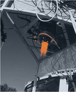 Real-world test of a hybrid engine with a bright vertical flame captured mid-burn on a structural frame, showcasing engine performance.